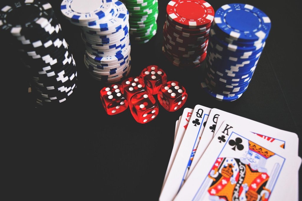 Fichas de cassino, cartas de baralho e dados sobre a mesa de jogo de apostas