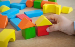 Criança brincando com blocos de madeira: plano de saúde para autista e reajuste abusivo