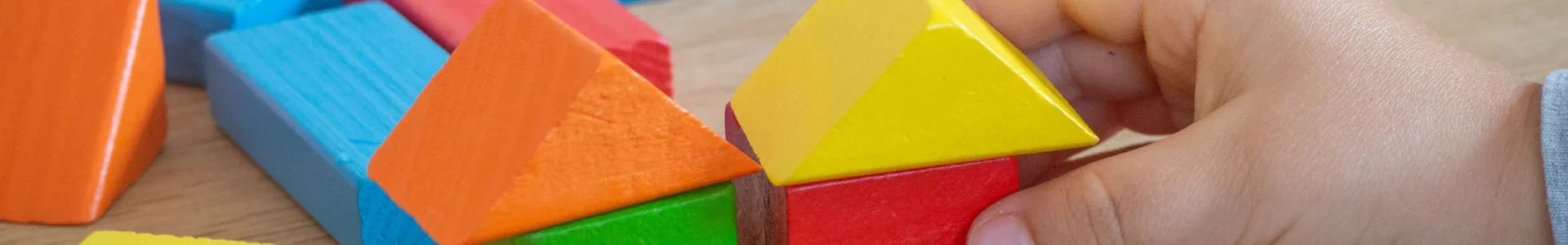 Criança brincando com blocos de madeira: plano de saúde para autista e reajuste abusivo
